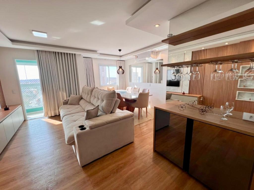 a large living room with a couch and a table at Apartamento 2 quartos com Vista in Bauru