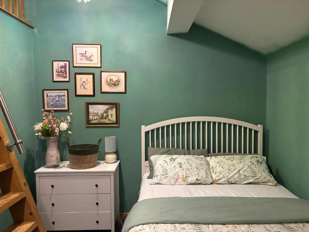 a bedroom with a bed and a green wall at Batty lodge in Cockerham