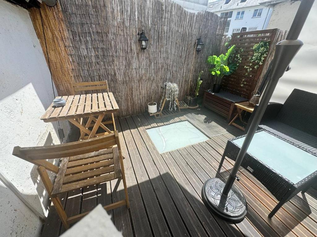 a deck with a bench and a table and a chair at Old Town Terrace Studio Trier in Trier