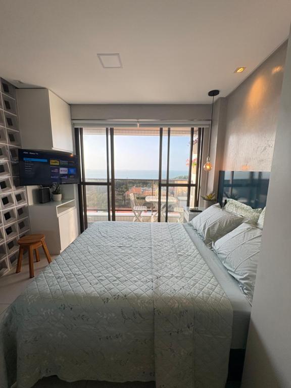 a bedroom with a large bed and a large window at STUDIO Mar azul 1206 in São Luís