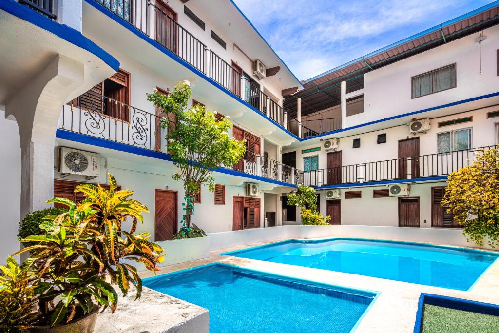 an apartment with a swimming pool in a building at Hotel Naxhiely in Puerto Escondido