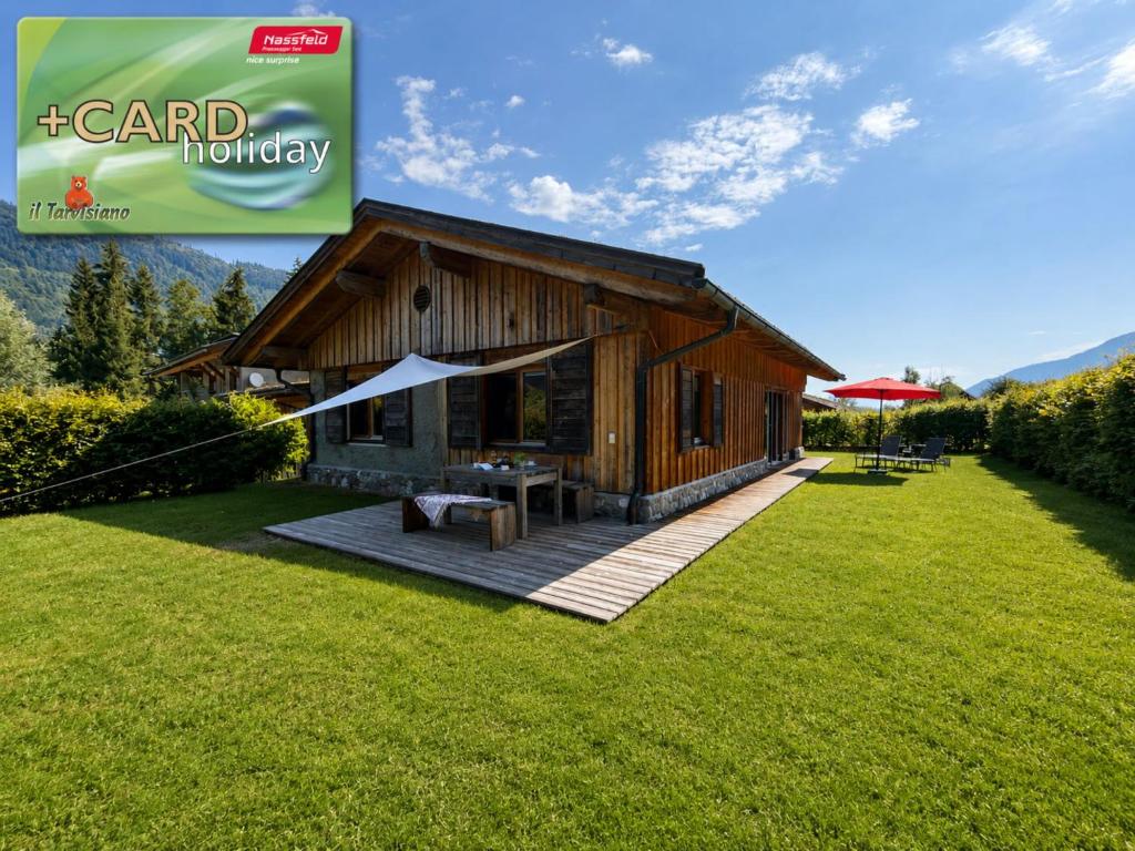 a small wooden house on a field of grass at Auen 53 in Lake Pressegg