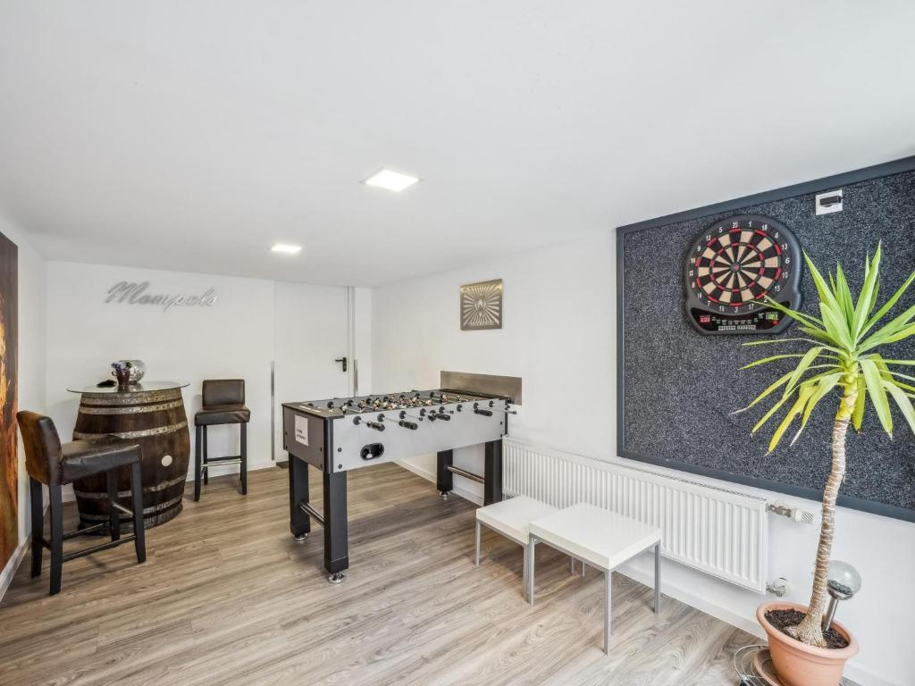 a room with a table and a dartboard on the wall at Mompels in Rübeland