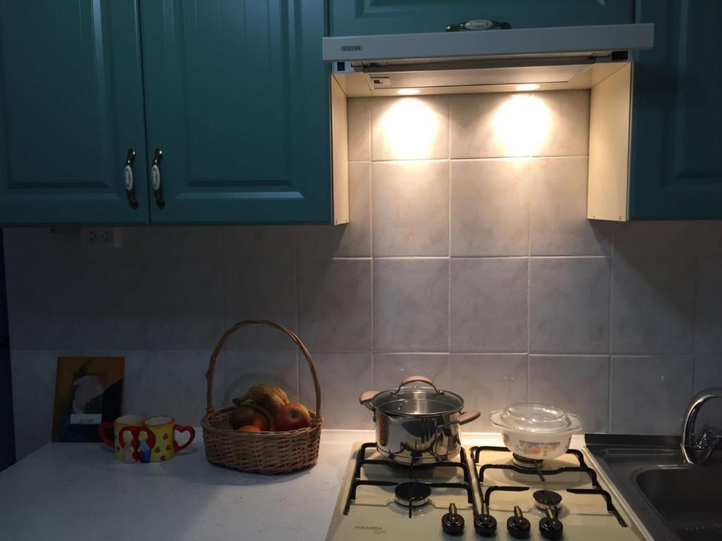 a kitchen stove with a pot and a basket of fruit at Holiday house near sea on Lvovskaya in Odesa
