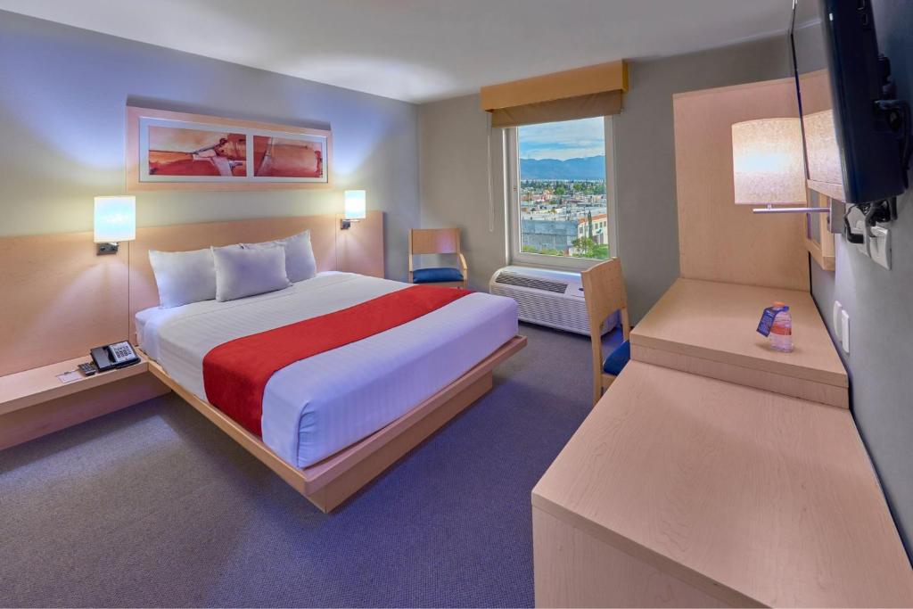 a bedroom with a large bed and a window at City Express by Marriott Saltillo Sur in Saltillo