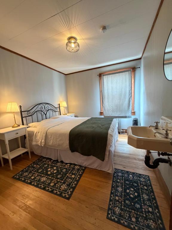 ein Schlafzimmer mit einem großen Bett, einem Waschbecken und einem Spülbecken in der Unterkunft Twin Cities Hotel in Turner Valley