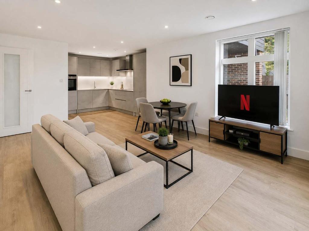 a living room with a couch and a tv at 2 Bedroom Addenbrookes Apartment in Trumpington