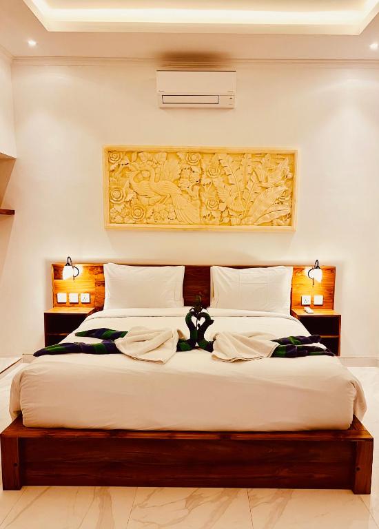 a bedroom with a large bed with white sheets at Ubud jungle House behind bintang supermarket ubud in Ubud