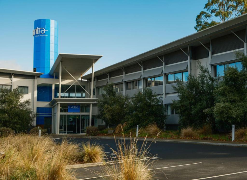 an office building with a water tower in the background at Mantra Hobart Airport in Hobart