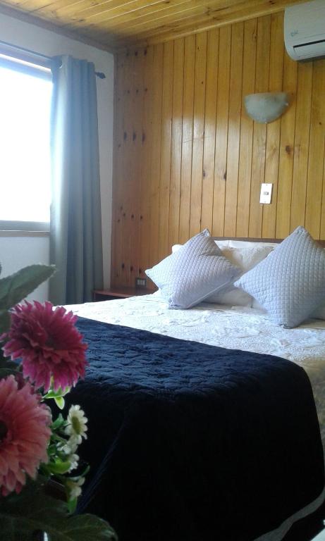 a bedroom with a bed with pillows and a window at Residencial del Maule in Linares
