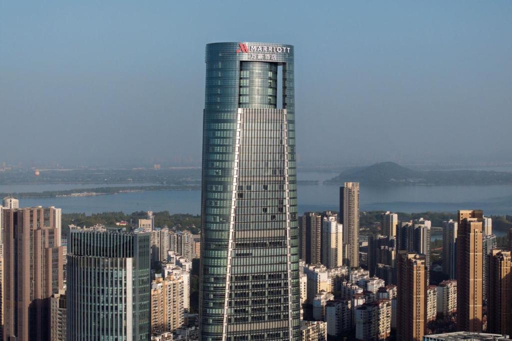 a tall skyscraper in the middle of a city at Wuhan Marriott Hotel Wuchang in Wuhan