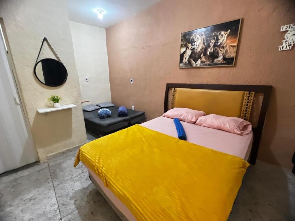 a bedroom with a bed with a yellow blanket on it at Recanto Carioca Aconchegante in Rio de Janeiro