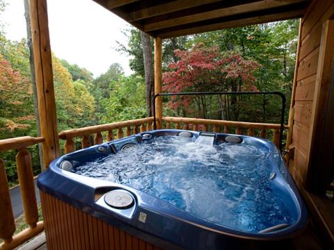 a blue hot tub sitting on a porch at Bear Loads of Fun in Sevierville