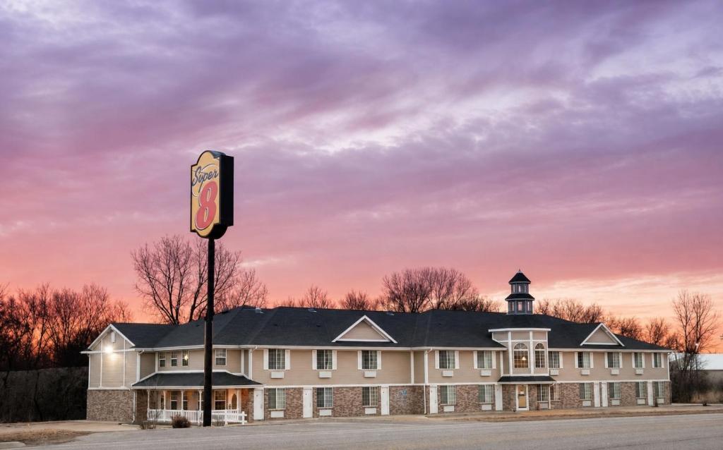 a large white building with a clock tower on top at Super 8 by Wyndham Arkansas City KS in Arkansas City