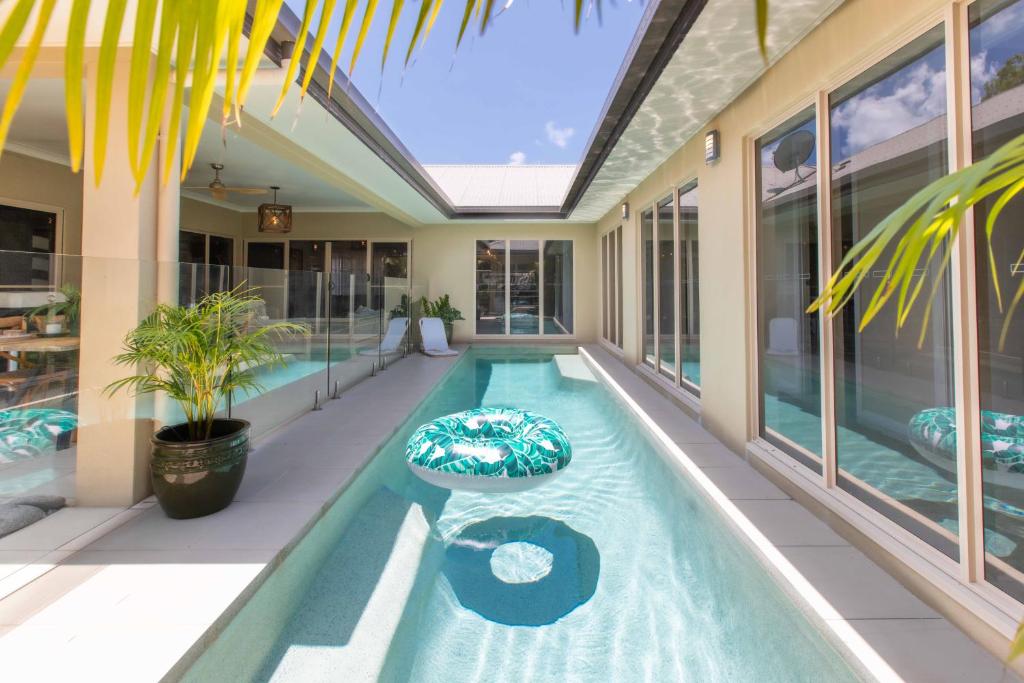 a swimming pool in the middle of a house at Escapades @ Palm Cove in Palm Cove