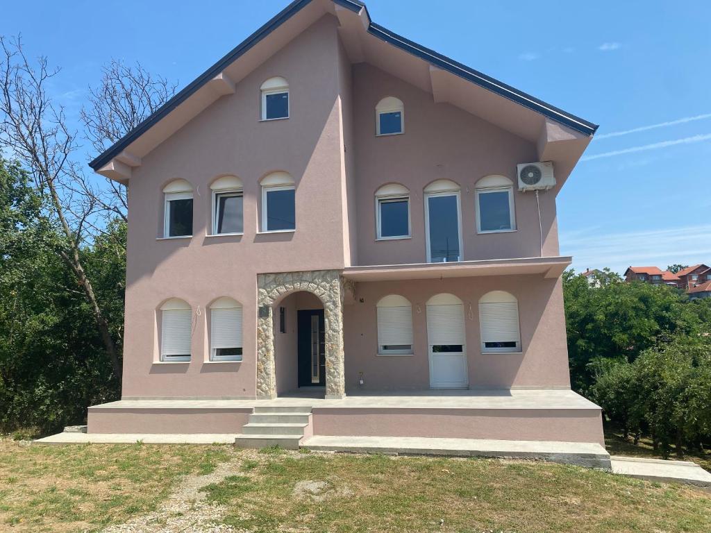 a pink house on top of a field at Kuća za odmor Aranđelovac in Arandelovac
