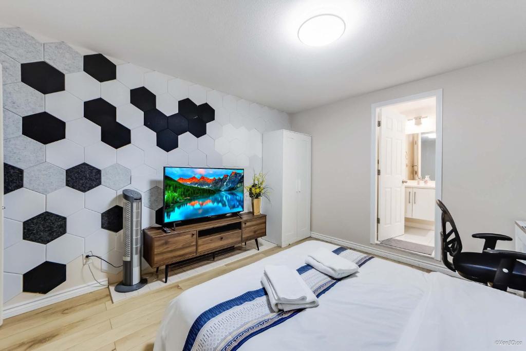 a bedroom with a bed and a flat screen tv at Bright Maple Suite in Richmond