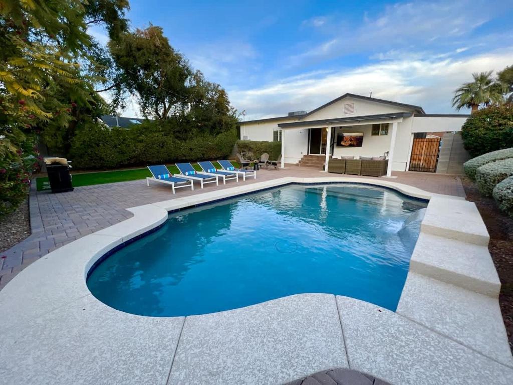 a swimming pool with blue chairs and a house at Casa Gia- Quiet Luxury Biltmore Area - Heated Pool in Phoenix
