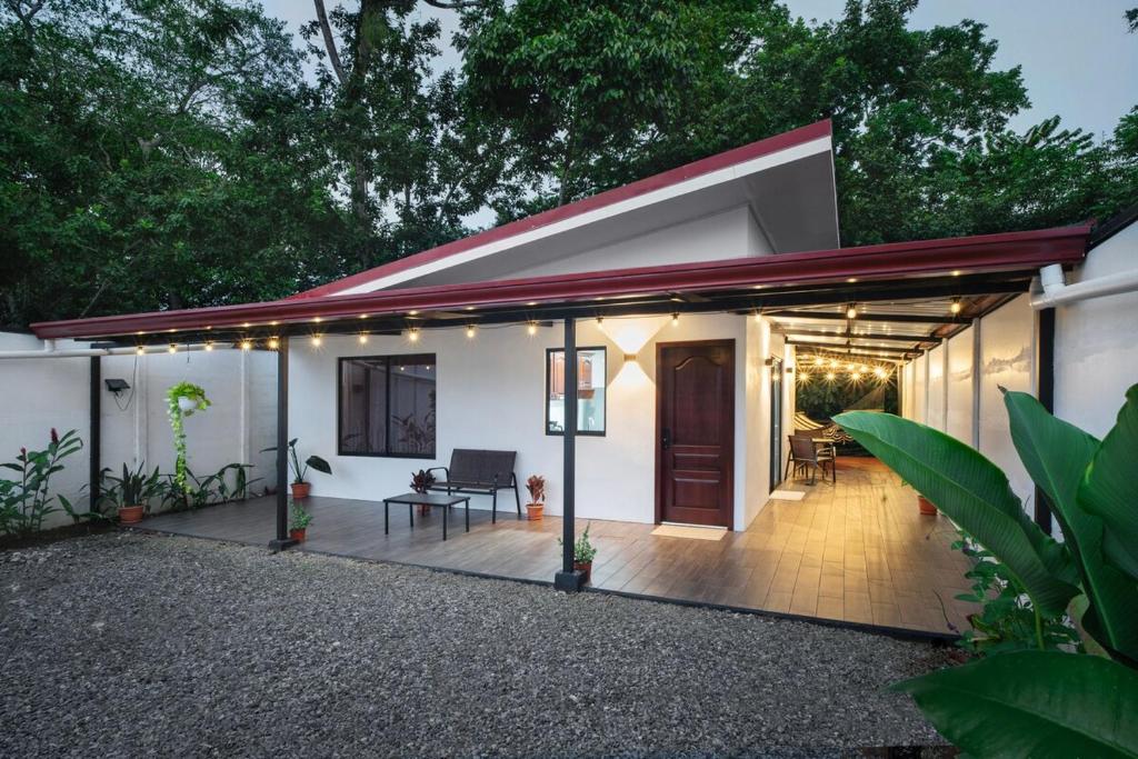 a white house with a red roof and a patio at Arenal Pecpen in Fortuna