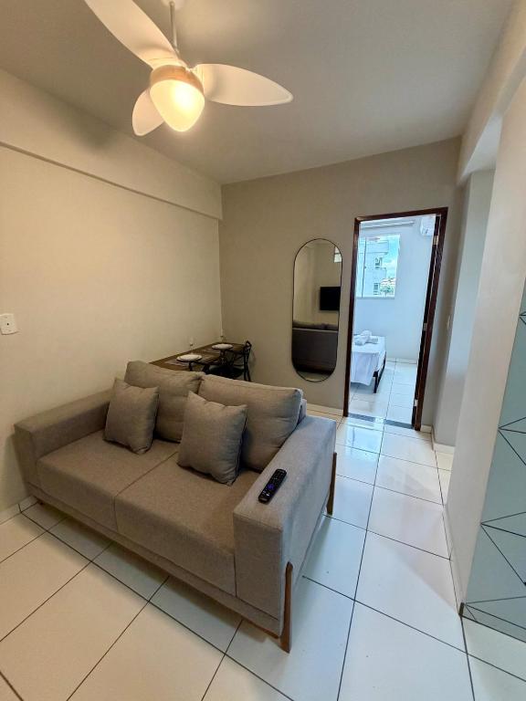 a living room with a couch and a ceiling fan at Apto com 2 quartos e A/C no Centro in Montes Claros