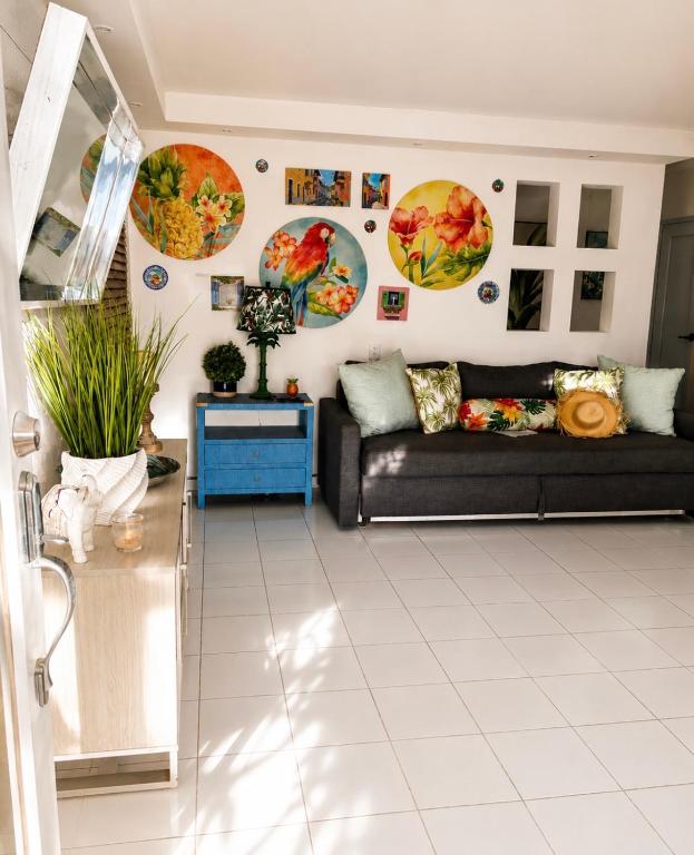 a living room with a couch and posters on the wall at Escape Caribeño in Levittown
