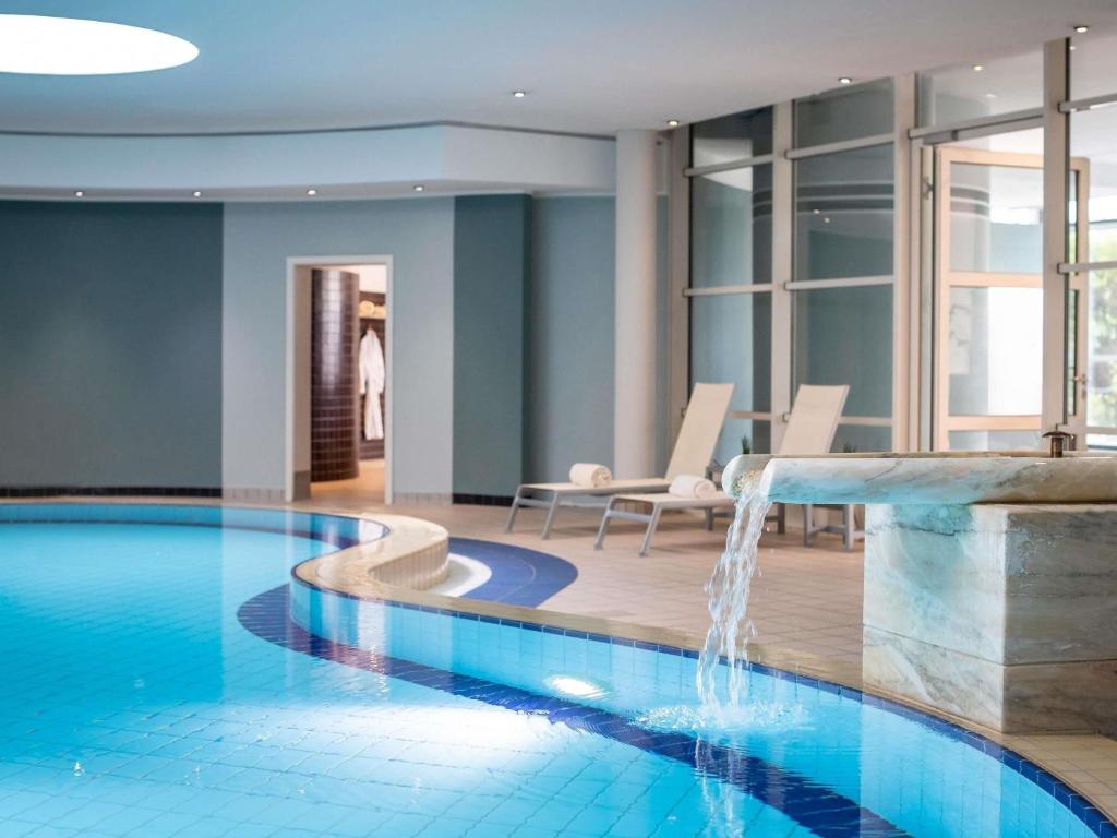 a pool with a waterfall in a hotel room at PULLMAN Stuttgart Fontana in Stuttgart