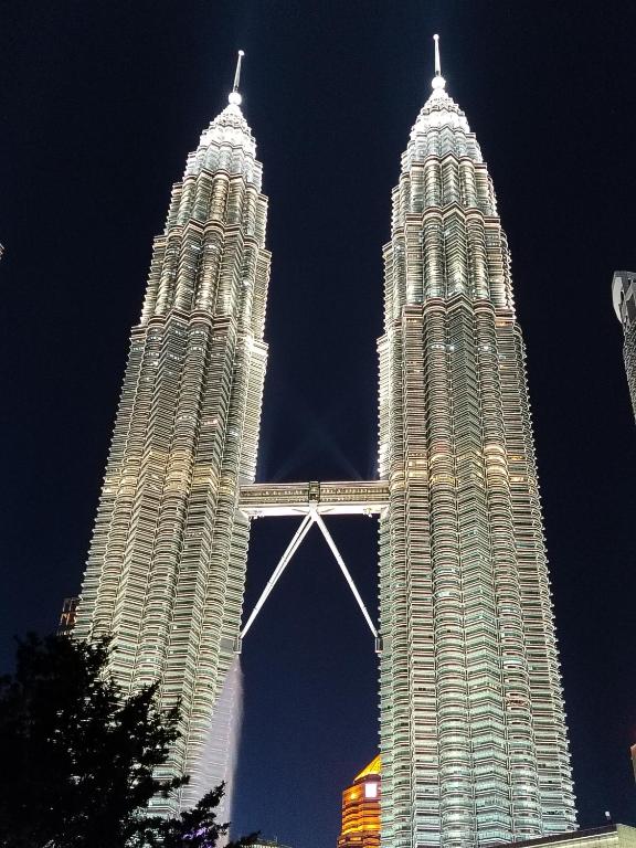 two tall towers are lit up at night at vortex luxury APATMENT BY FRINDSHIP in Kuala Lumpur