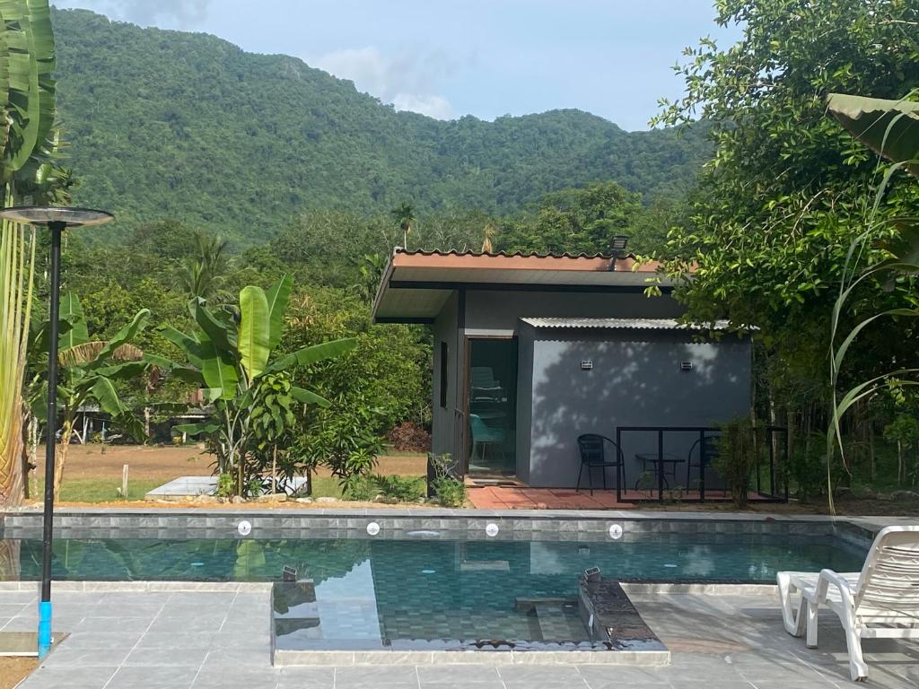 a resort with a swimming pool and a house at Noi’s Paradise Homestay in Phatthalung