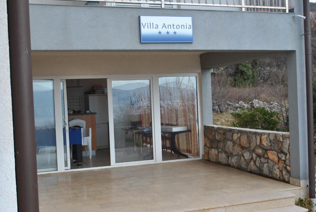 a building with a glass door with a table inside at Villa Antonia in Klenovica