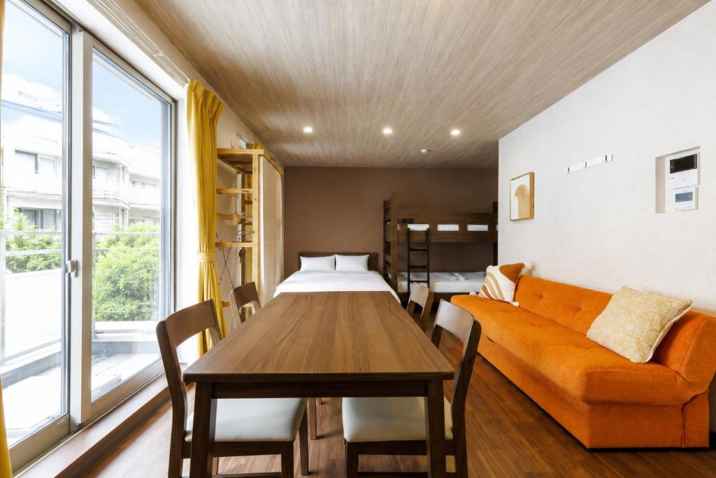 a room with a table and a couch and a bed at ミニョン マッペ in Osaka