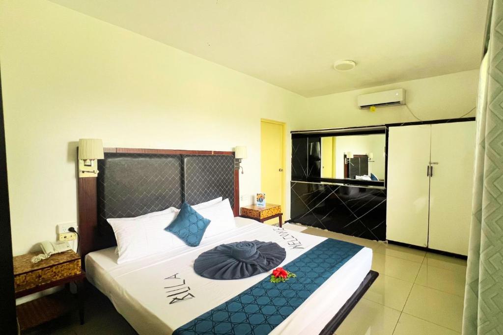 a bedroom with a large bed with blue pillows at Townhouse Apartment Hotel Suva in Suva