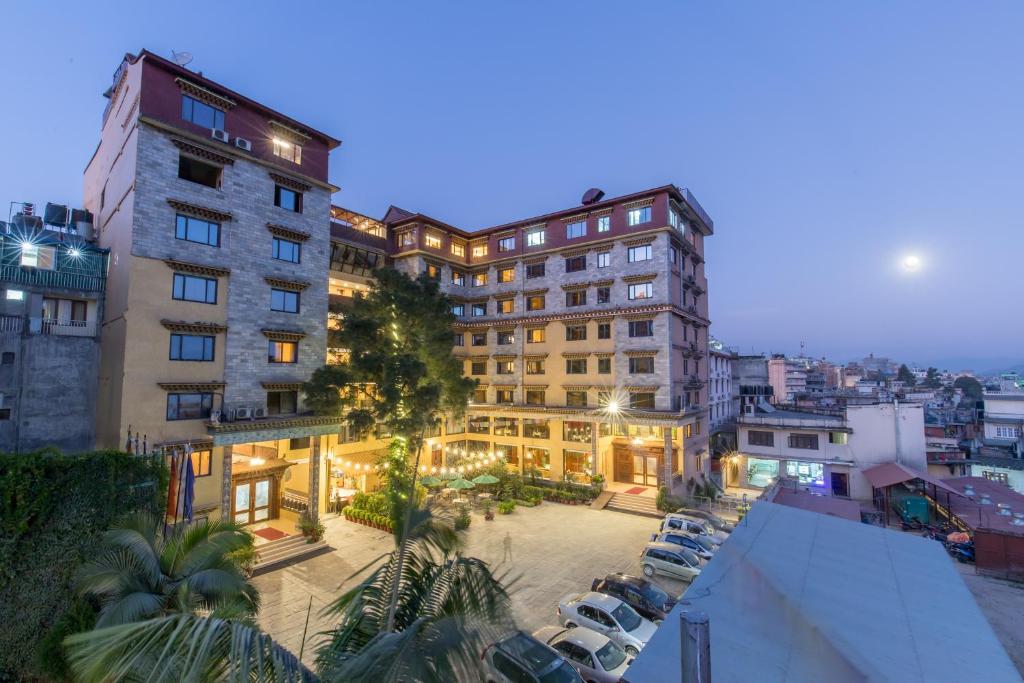 a building with a parking lot in a city at night at Hotel Tibet International in Kathmandu