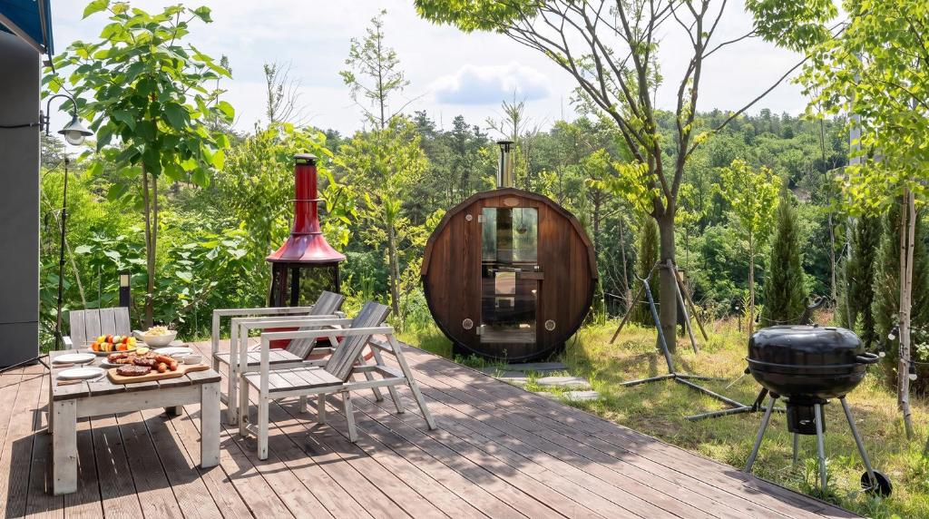 a deck with a bbq and a grill at Sokcho Biroso Private Cottage in Sokcho