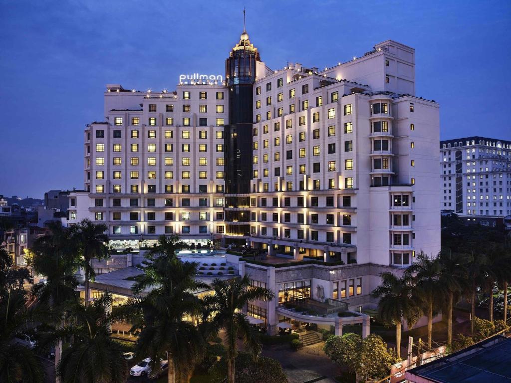 a large white building with a clock tower on top at Pullman Hanoi in Hanoi