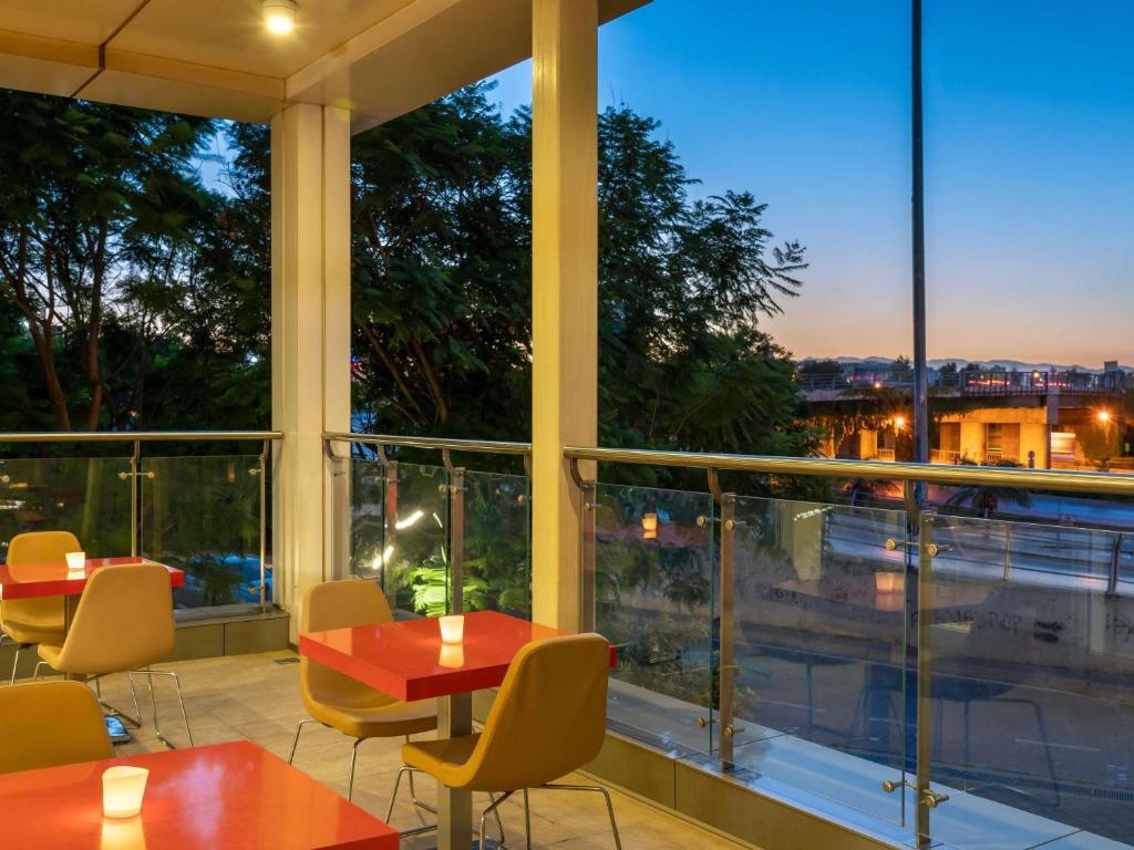 a restaurant with tables and chairs and a view of the city at ibis Adana in Adana