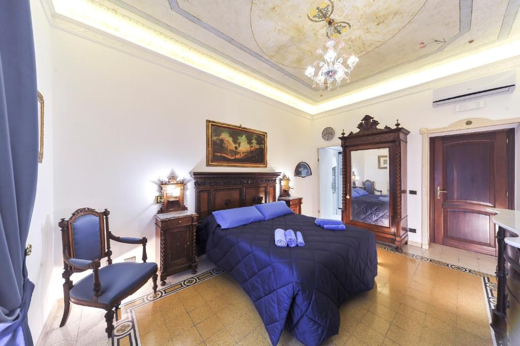 a bedroom with a bed with blue sheets and a chair at Central Domus Roma in Rome