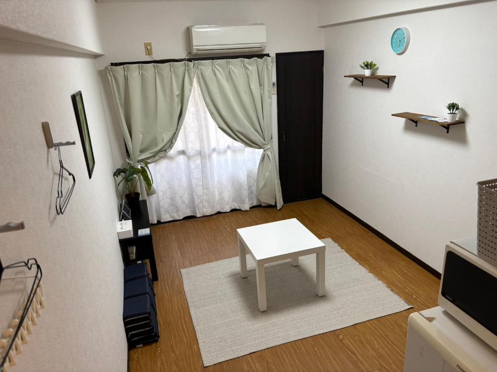 a living room with a table and a window at アルゴ境川 in Kitakyushu