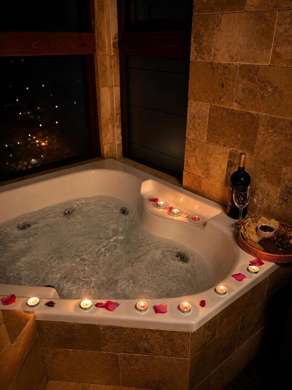 a bath tub with candles and lights in it at Hotel Peregrino Suites in Concepción
