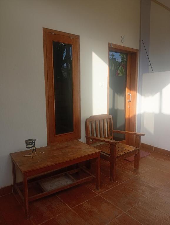 a room with a wooden table and a chair at Mamat warung bed & breakfast in Huu