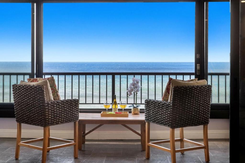 a table and chairs in a room with a view of the ocean at Maui Kai 405 in Honokowai