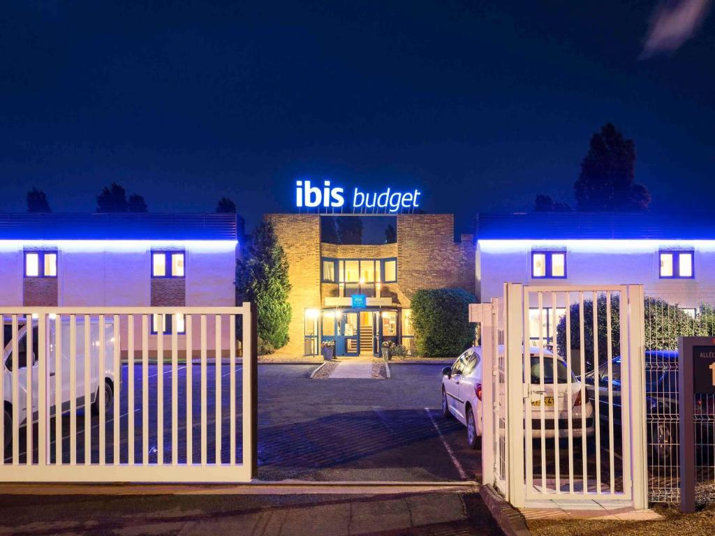 a building with a gate in front of a building at ibis budget Châtellerault Nord in Châtellerault