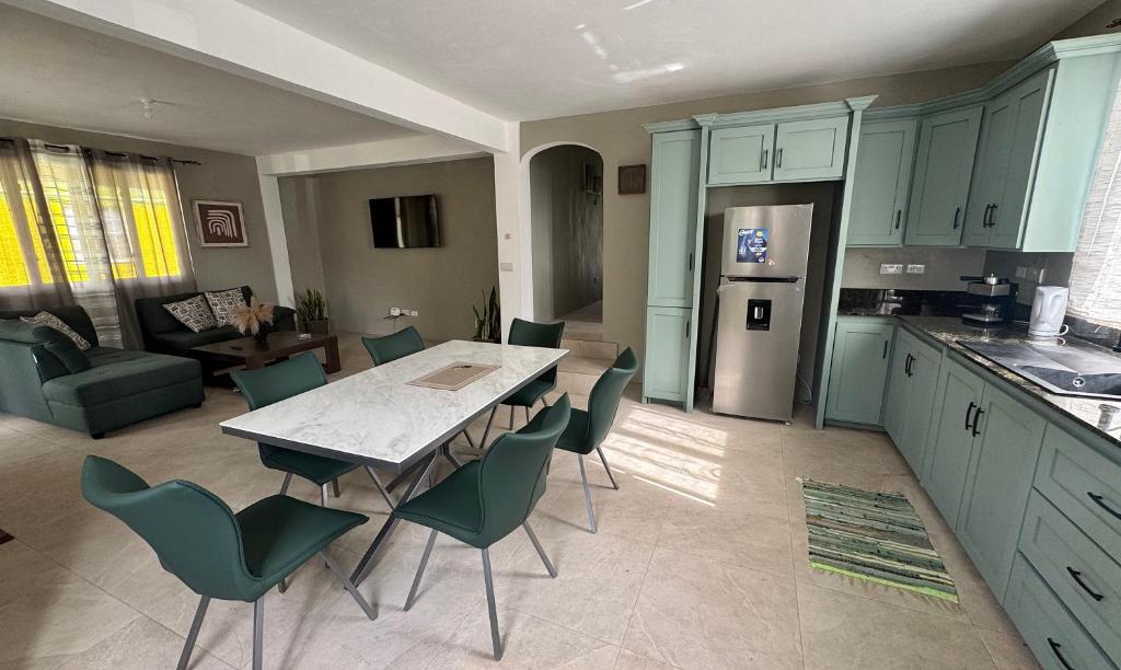 a kitchen with a table and chairs and a living room at Vacation Guesthouse in Paix Bouche