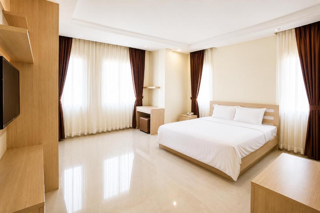 a bedroom with a bed and a flat screen tv at Phnom Penh Star Apartment in Phnom Penh