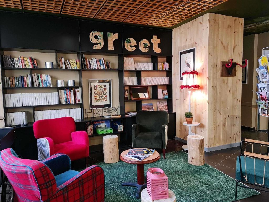 a store with two chairs and a table and books at Greet Hotel Evreux Centre - Route de Normandie by Accor in Évreux