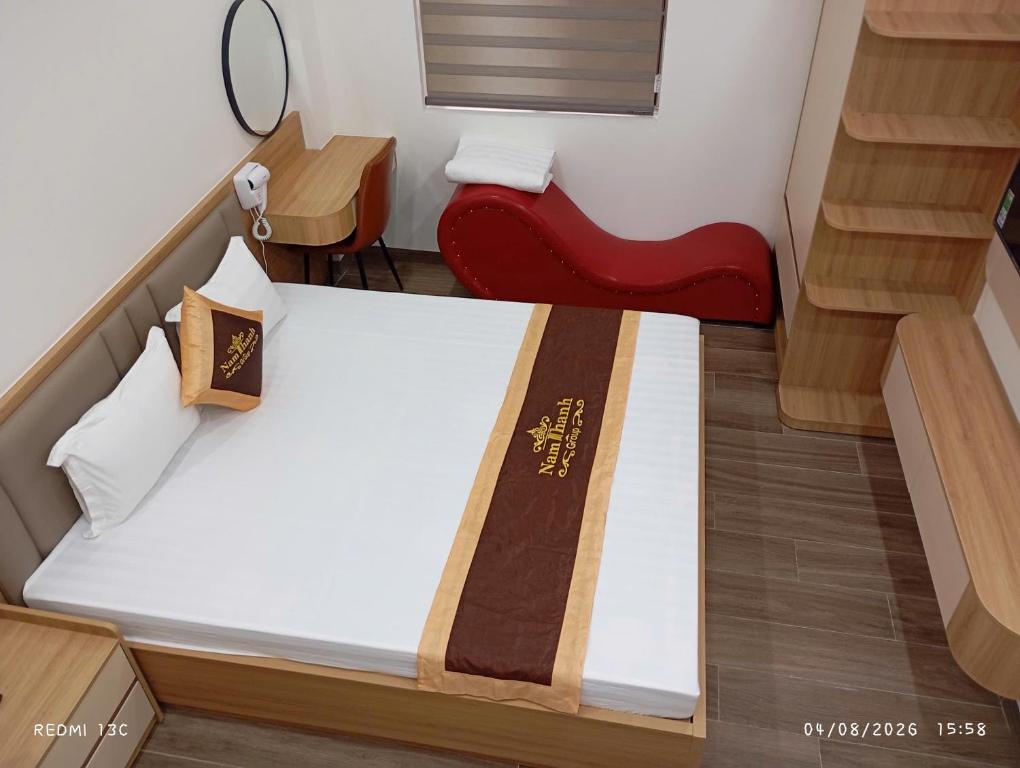 a small room with a bed and a red bench at Nam Thanh Hotel in Nhật Tựu
