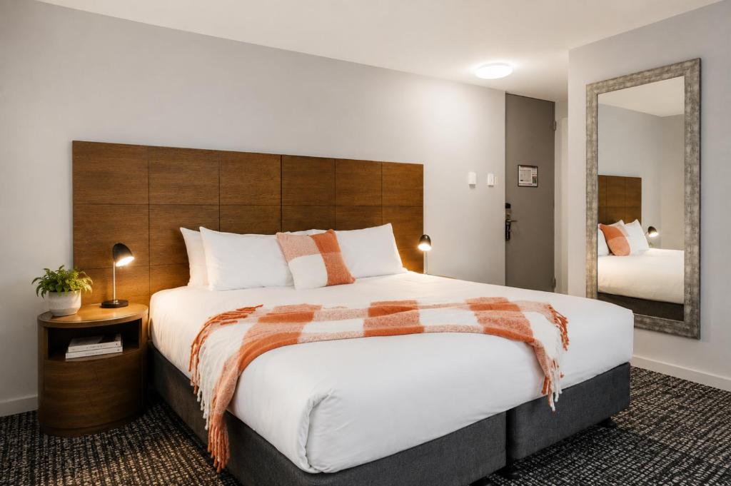a bedroom with a large bed and a mirror at Punthill Spring Hill in Brisbane