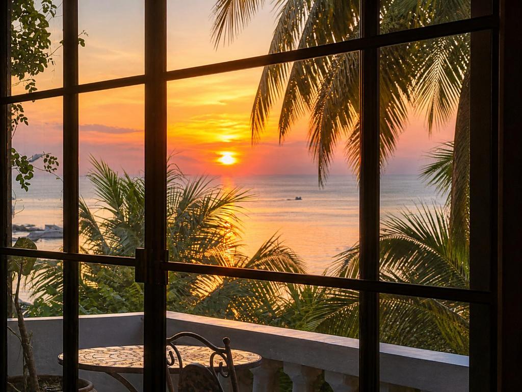 a view of the sunset from a room with a window at Tea Moon Boutique Stay in Thong Sala