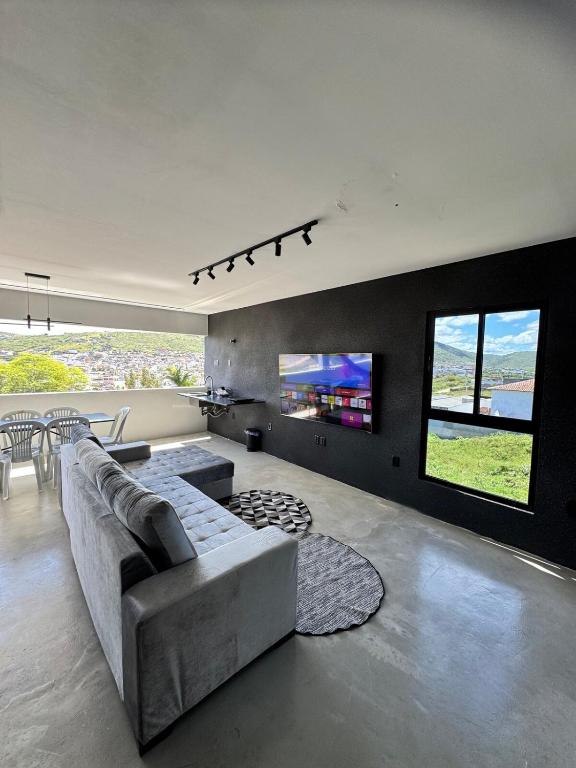 a living room with a couch and a tv at Arcoverde - Varanda com Vista Panorâmica - excelente localização - até 6 pessoas in Arcoverde