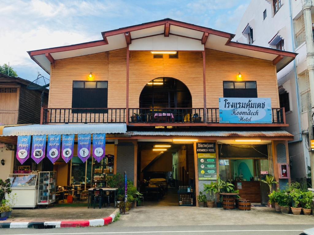 eine Ladenfront eines Gebäudes mit Balkon in der Unterkunft โรงแรมคุ้มเดช - KoomDech Hotel in Sattahip