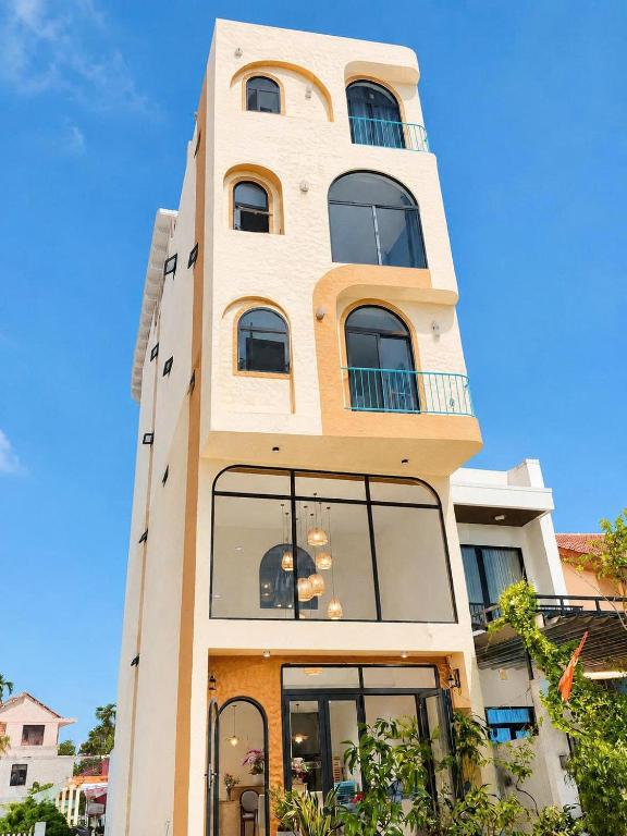 a tall building with large windows at La Riva Riverside Hue Hotel & Rooftop in Hue